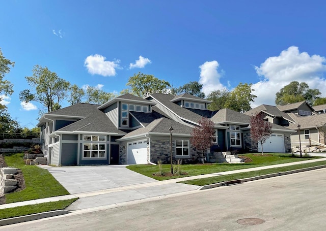 view of front of property with driveway, stone siding, a shingled roof, a front yard, and an attached garage