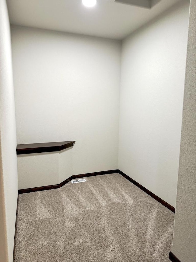 carpeted empty room featuring visible vents and baseboards