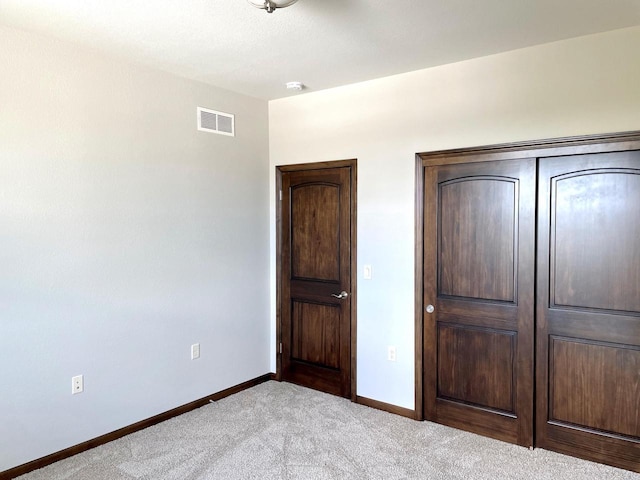 unfurnished bedroom with baseboards, visible vents, and light carpet