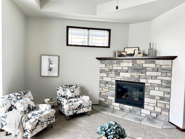 carpeted living room featuring a fireplace and a tray ceiling