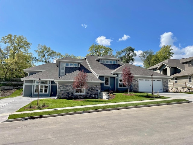 view of front of home featuring a garage, stone siding, a front lawn, and driveway