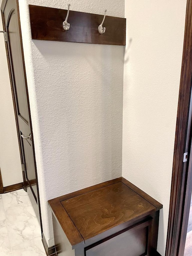 mudroom with a textured wall and marble finish floor