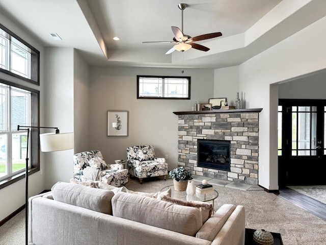 living area with a raised ceiling, visible vents, and a wealth of natural light