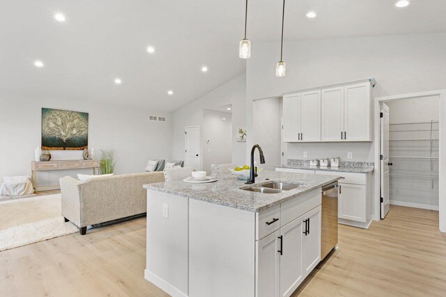 kitchen with a sink, light wood-style floors, open floor plan, and white cabinets