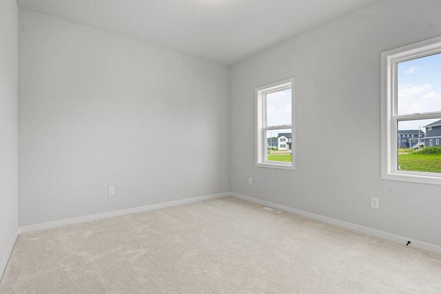 empty room with light carpet and baseboards