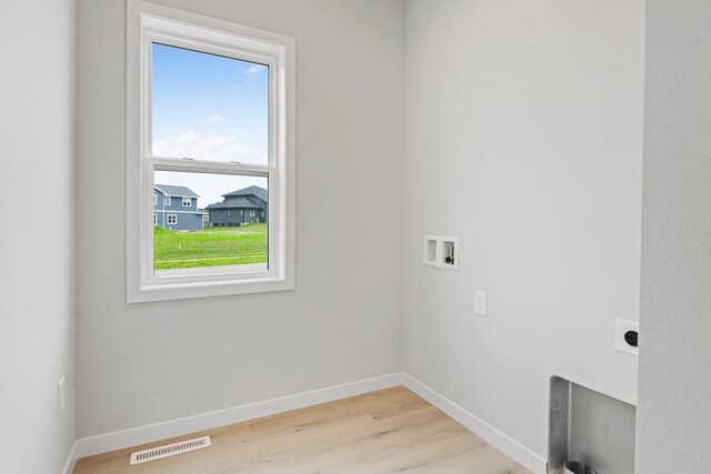 laundry room featuring baseboards, visible vents, laundry area, light wood-style flooring, and electric dryer hookup
