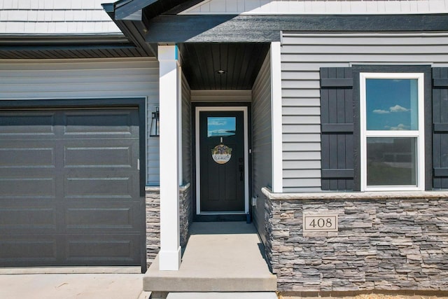 doorway to property featuring a garage and stone siding