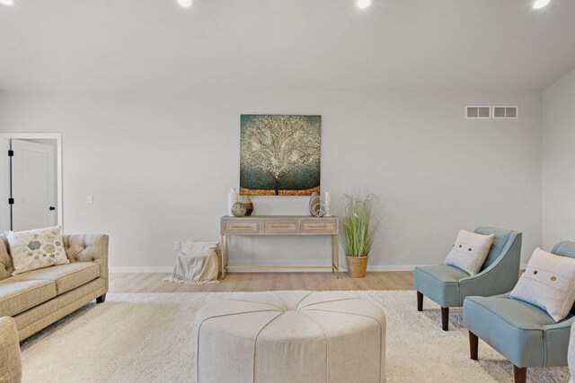 living room with visible vents, baseboards, and wood finished floors