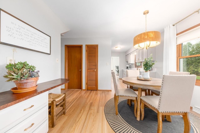 dining room featuring light wood-type flooring and baseboards