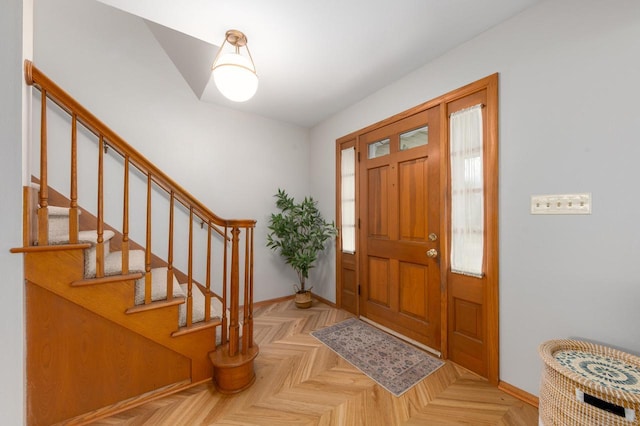 foyer featuring stairs and baseboards