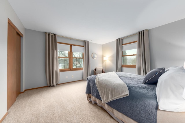 bedroom with baseboards, multiple windows, and carpet