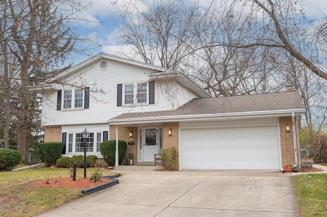 traditional-style house with roof with shingles, an attached garage, concrete driveway, a front lawn, and brick siding