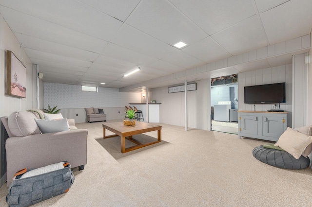 living room with washer / clothes dryer and carpet