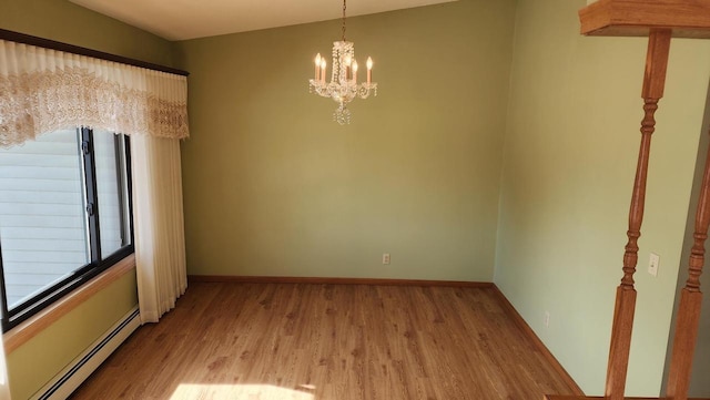 empty room with an inviting chandelier, baseboards, light wood-type flooring, and a baseboard radiator