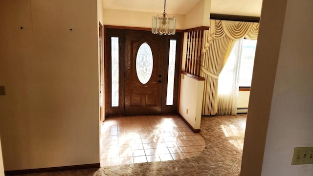 carpeted foyer featuring a baseboard heating unit, baseboards, and a notable chandelier