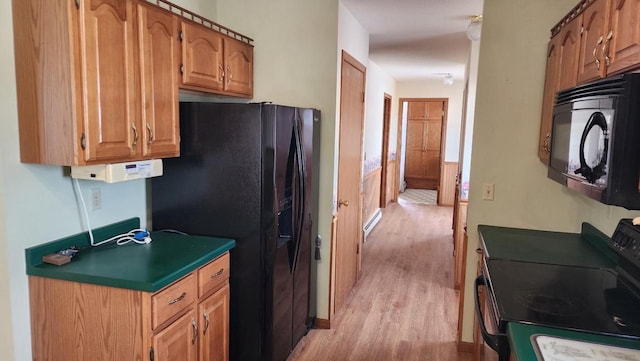 kitchen with black appliances, brown cabinets, light wood-type flooring, and a baseboard radiator