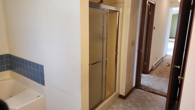 bathroom featuring baseboard heating, a shower stall, baseboards, and a garden tub