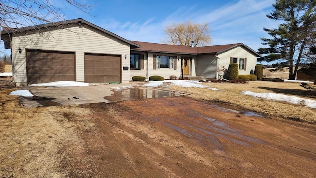 single story home featuring concrete driveway and an attached garage