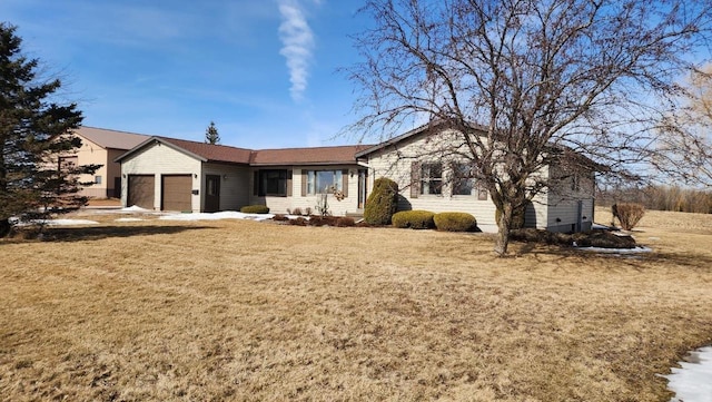 ranch-style home with a garage and a front lawn