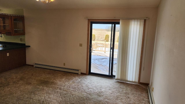 unfurnished dining area with baseboards, baseboard heating, and carpet flooring