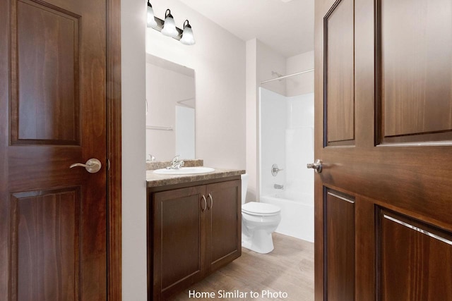 full bath with vanity, toilet, wood finished floors, and shower / bath combination