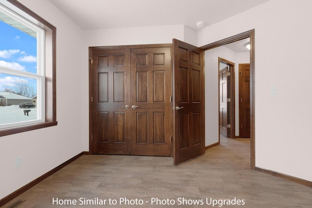 interior space featuring light wood-type flooring, baseboards, and visible vents