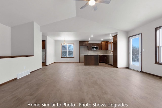 unfurnished living room featuring light wood-type flooring, visible vents, baseboards, and ceiling fan with notable chandelier