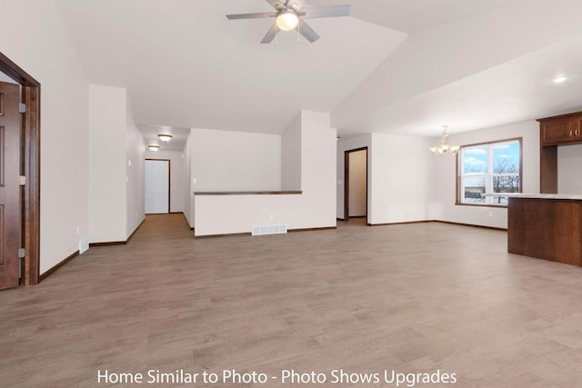 unfurnished living room with visible vents, light wood-type flooring, baseboards, and vaulted ceiling