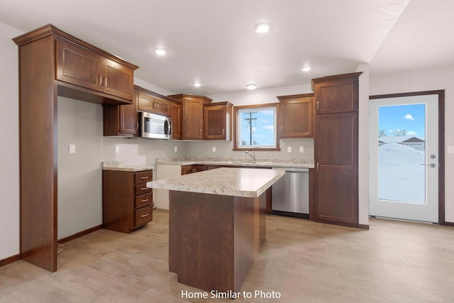 kitchen featuring baseboards, recessed lighting, light countertops, appliances with stainless steel finishes, and a center island