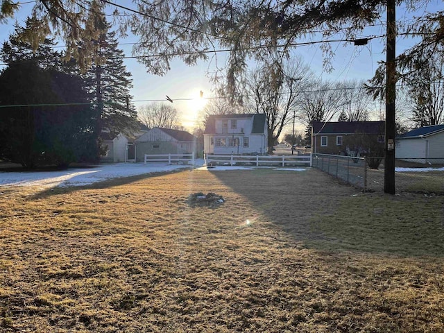 yard at dusk featuring fence