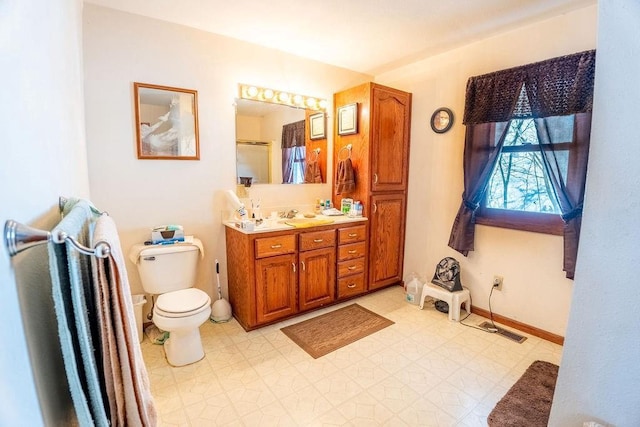 bathroom featuring baseboards, toilet, tile patterned floors, vanity, and a shower