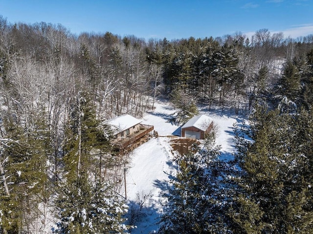 snowy aerial view featuring a forest view