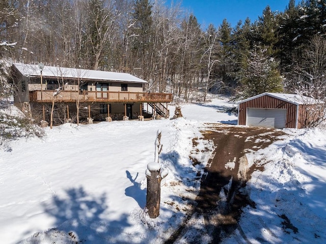 view of front of property with a garage, a deck, an outdoor structure, and stairs