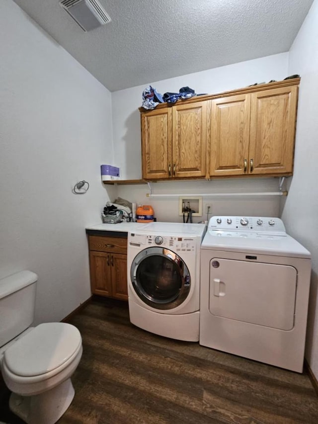 laundry room with visible vents, independent washer and dryer, a textured ceiling, and dark wood-type flooring