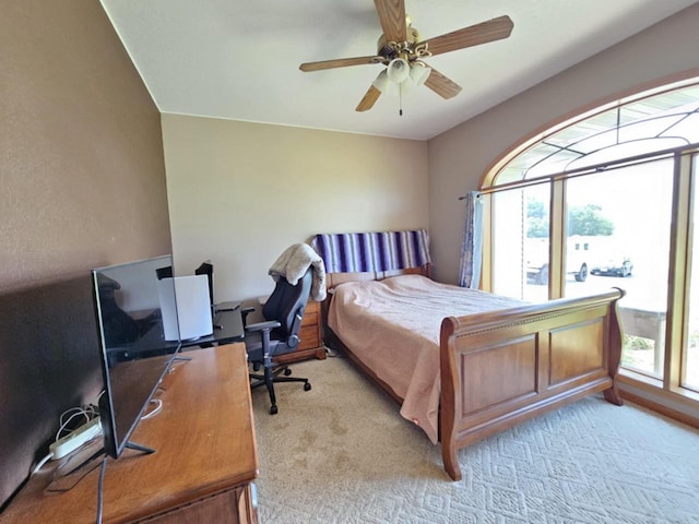 bedroom featuring light colored carpet and a ceiling fan