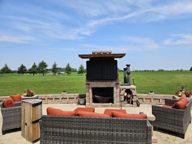 view of patio / terrace with an outdoor living space with a fireplace and a rural view