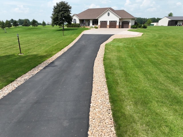 view of front of house with a front lawn, an attached garage, and driveway