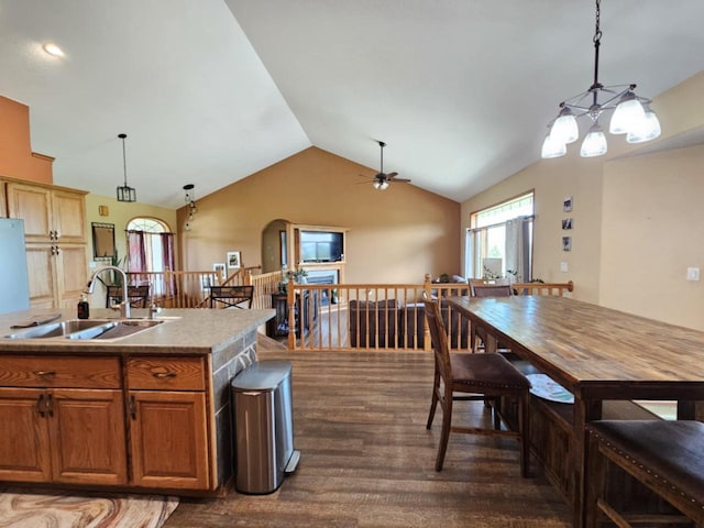 kitchen with dark wood finished floors, decorative light fixtures, lofted ceiling, and a sink