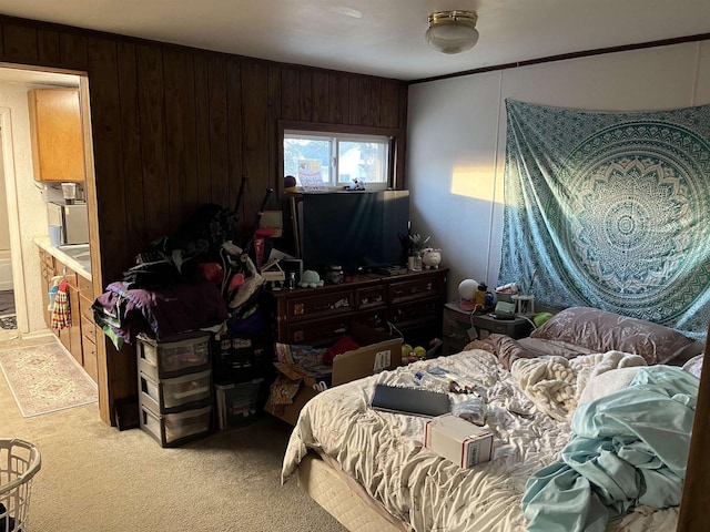 bedroom featuring light colored carpet and wood walls