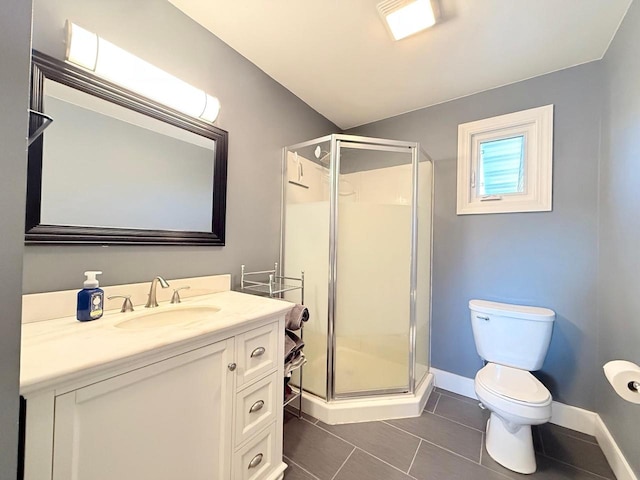 bathroom with tile patterned flooring, baseboards, toilet, a stall shower, and vanity