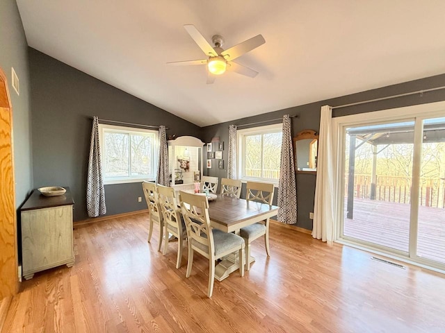 dining room featuring plenty of natural light, lofted ceiling, and light wood-style floors