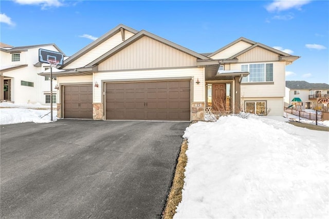 view of front of property with stone siding, driveway, and a garage