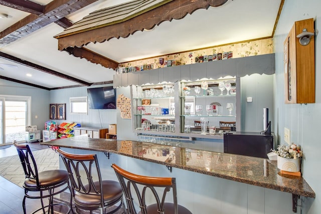 bar with lofted ceiling with beams and a dry bar