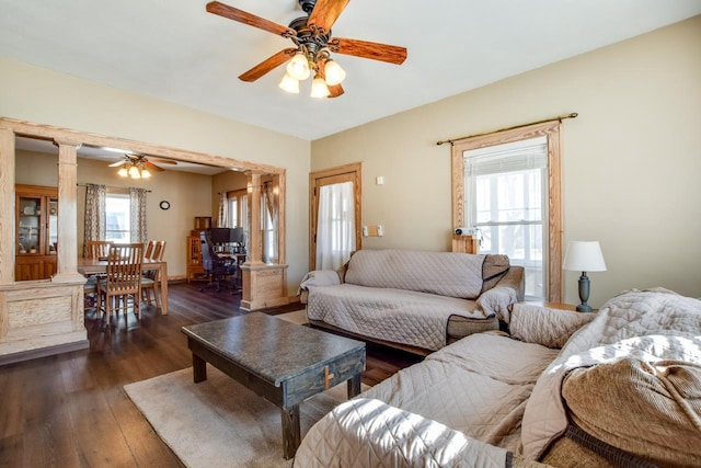 living room with dark wood-type flooring, a healthy amount of sunlight, ornate columns, and ceiling fan