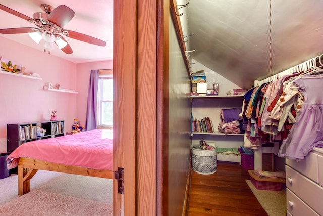 interior space with a ceiling fan, vaulted ceiling, and wood finished floors