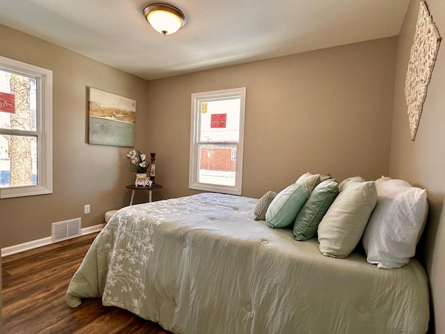 bedroom featuring dark wood-type flooring, baseboards, and visible vents