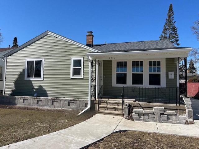 rear view of property with a porch, a chimney, roof with shingles, and crawl space