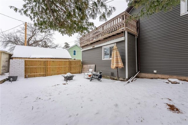 snow covered property with a fire pit and fence