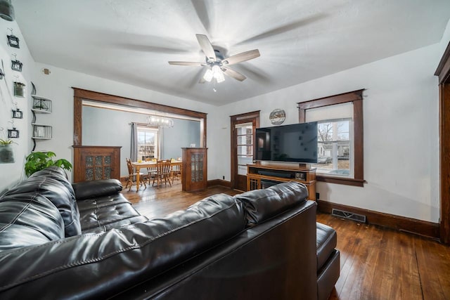 living area featuring a wealth of natural light, visible vents, baseboards, and dark wood-style flooring