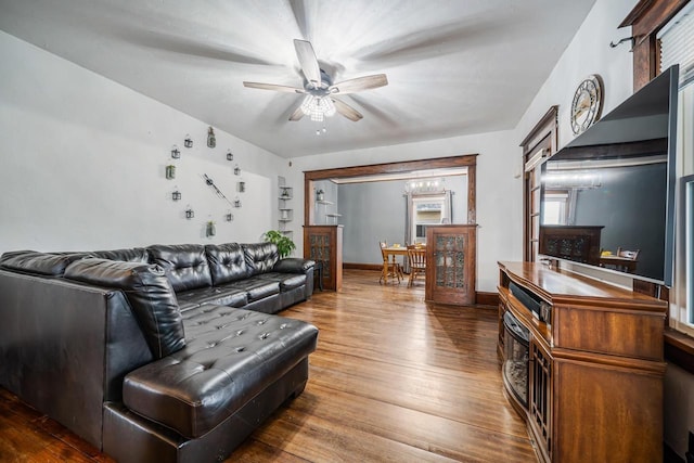 living area featuring baseboards, wood finished floors, and a ceiling fan